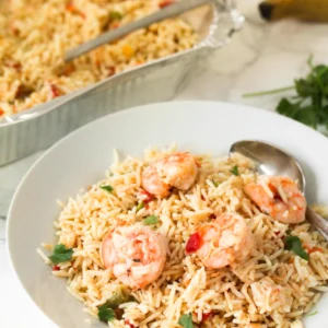 Coconut-rice-with-shrimp-and-vegetables-in-a-white-plate-with-a-silver-spoon